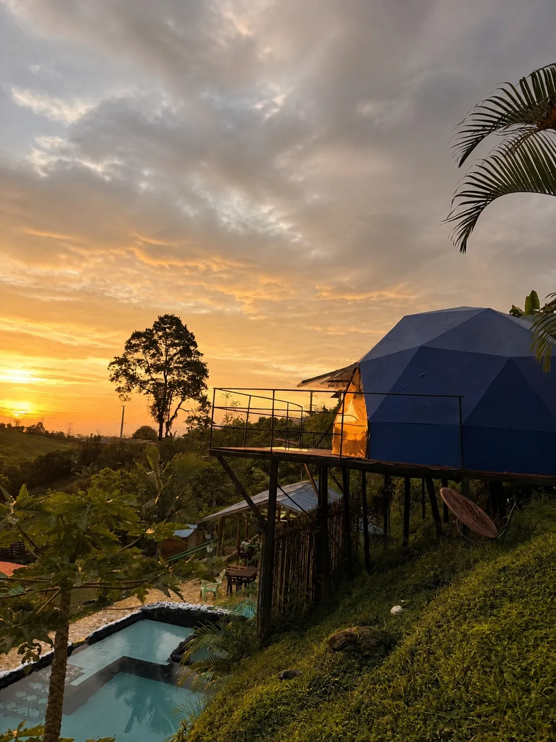Atardecer junto al domo azul y la piscina del glamping