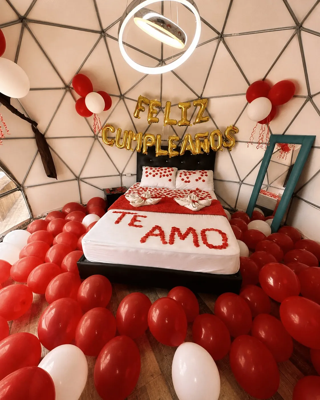 Decoración romántica con mensaje y globos sobre la cama
