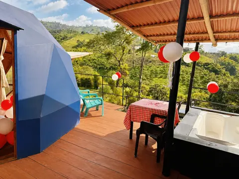 Terraza con tina de agua caliente del domo azul y vista al paisaje verde